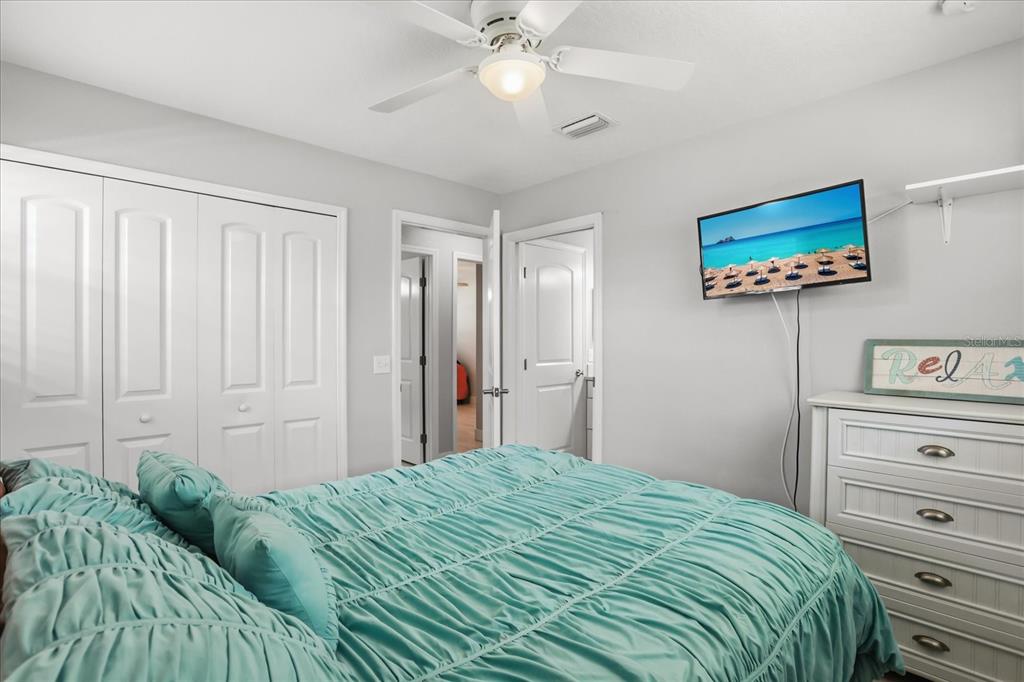 159 Holland Road Ormond Beach, FL 32176 - Photo 15 of 55 a bedroom with a bed and a chandelier