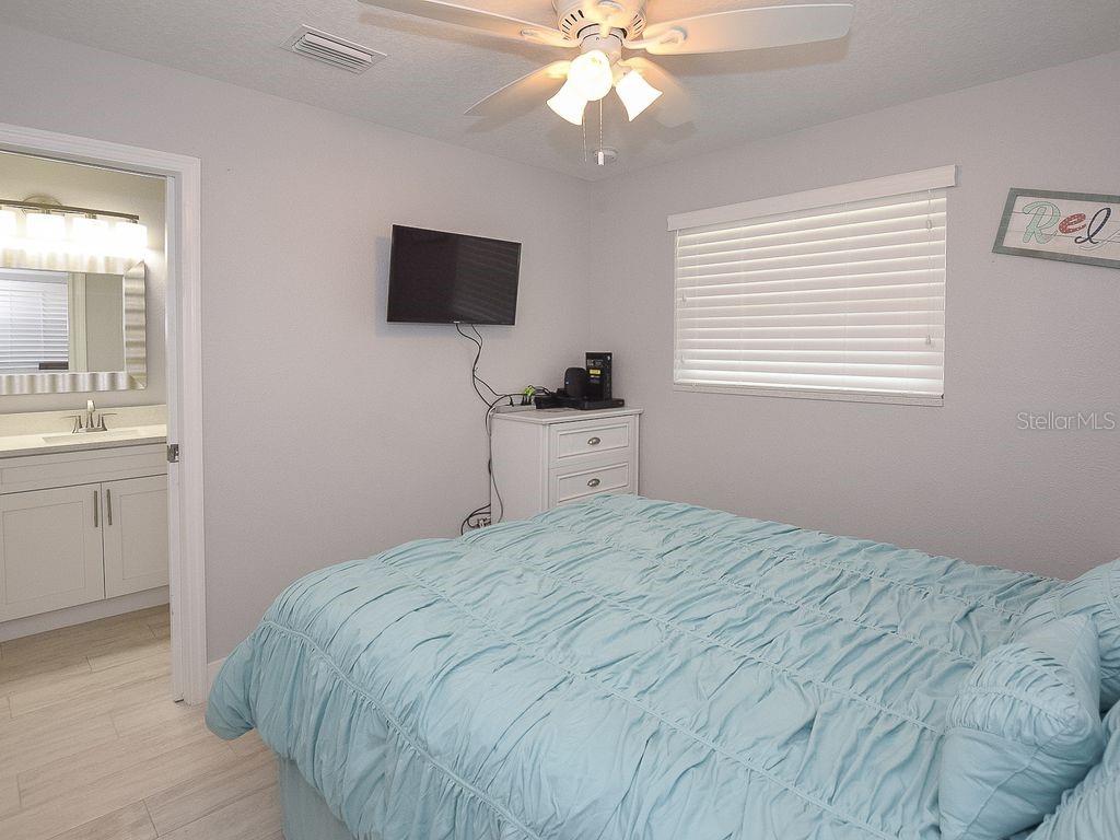 159 Holland Road Ormond Beach, FL 32176 - Photo 16 of 55 a bedroom with a bed and a flat tv screen on dresser