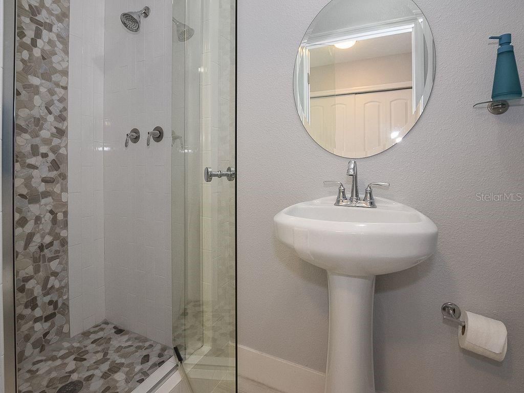 159 Holland Road Ormond Beach, FL 32176 - Photo 21 of 55 a bathroom with a sink a mirror and a shower