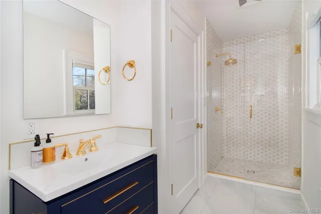 a bathroom with a sink a mirror and a shower