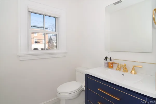 a bathroom with a sink a toilet and a window