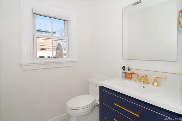 a bathroom with a sink a toilet and a window