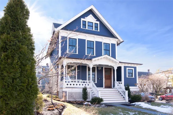 a front view of a house with yard and parking