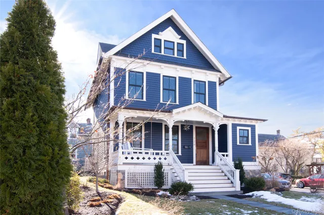 a front view of a house with yard and parking