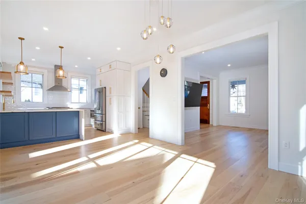 a large kitchen with a window and wooden floor