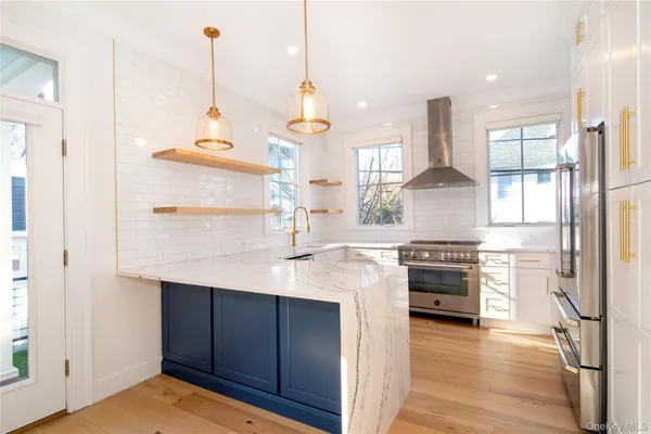 a kitchen with stainless steel appliances granite countertop a sink a stove and a wooden floors