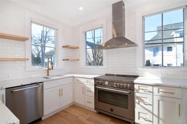a kitchen with stainless steel appliances a sink stove and cabinets