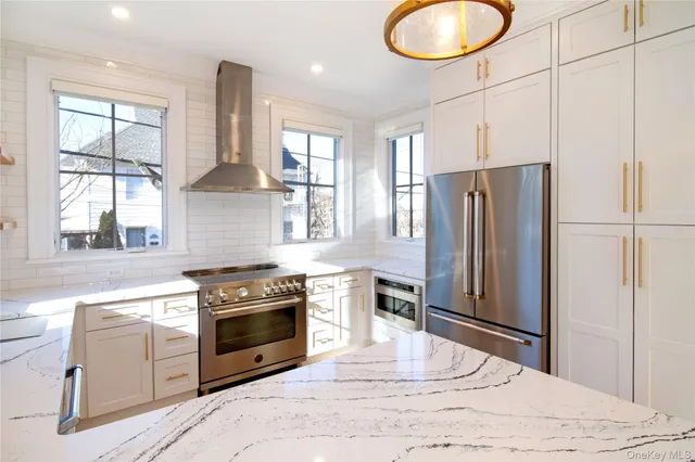 a kitchen with a stove a refrigerator and windows