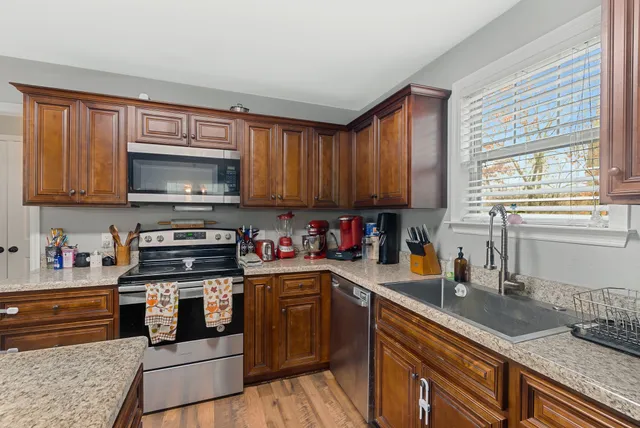 a kitchen with stainless steel appliances granite countertop a stove sink microwave and cabinets