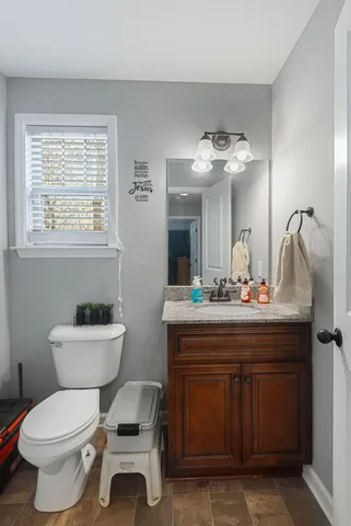 a bathroom with a toilet a sink and mirror