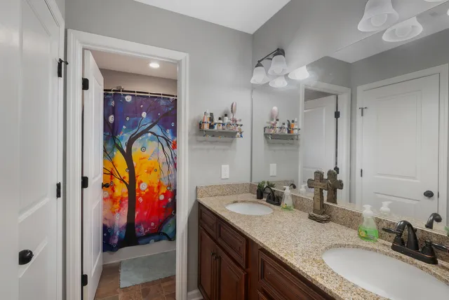 a bathroom with a granite countertop sink a mirror and a shower