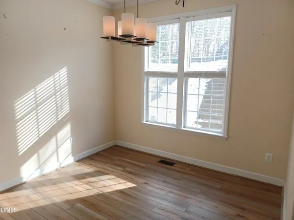 a view of a hallway with wooden floor and entryway