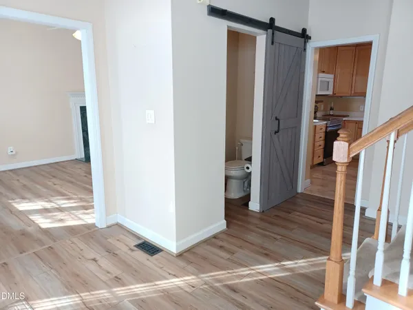 an empty room with wooden floor fireplace and window