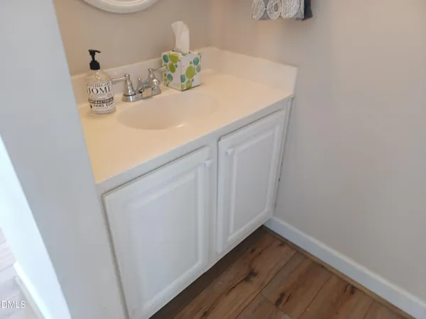 a view of a hallway with wooden floor and chandelier