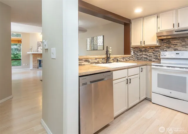 a kitchen with white cabinets and white appliances
