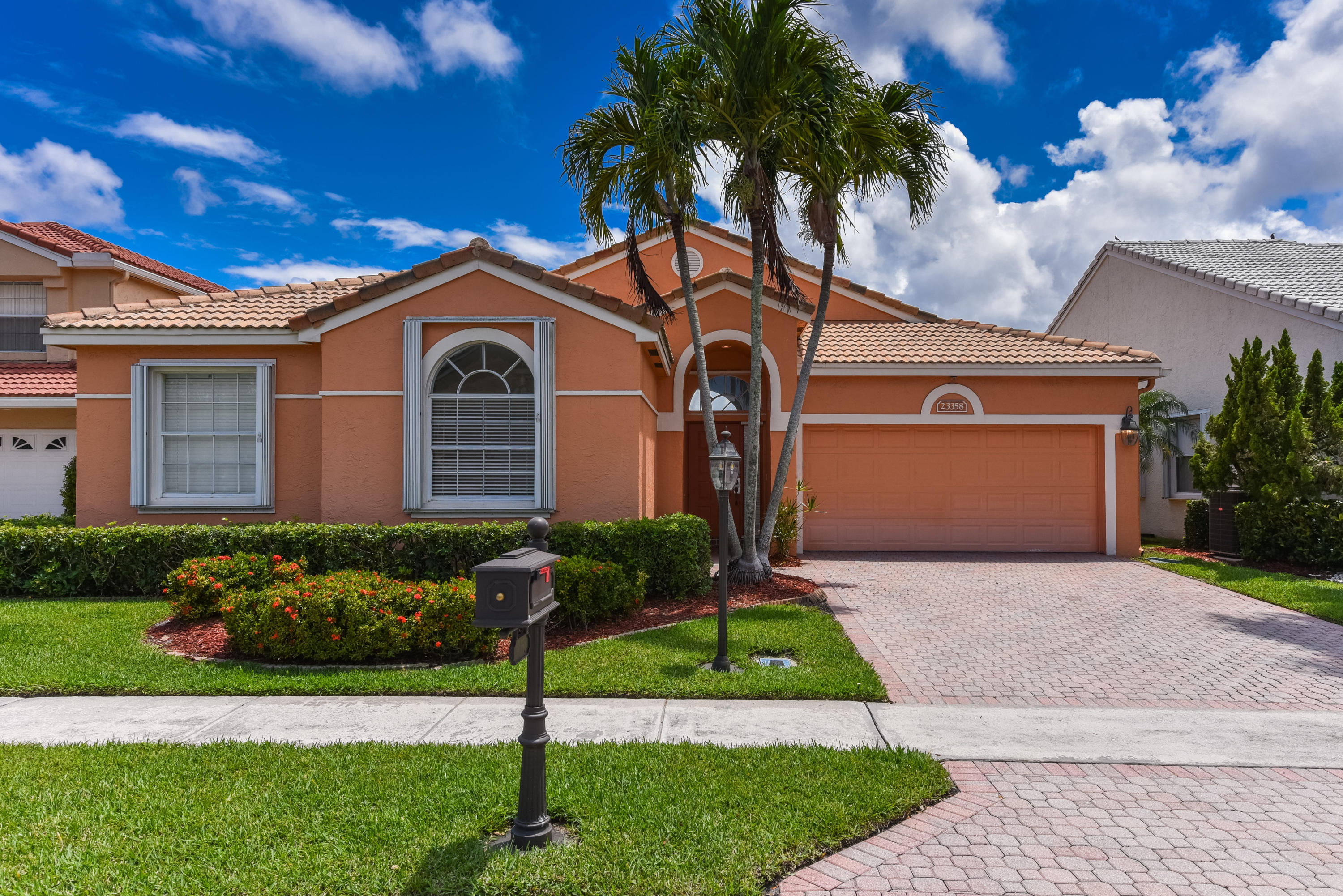 23358 Torre Circle Boca Raton, FL 33433 - Photo 1 of 34 a front view of a house with a garden and plants
