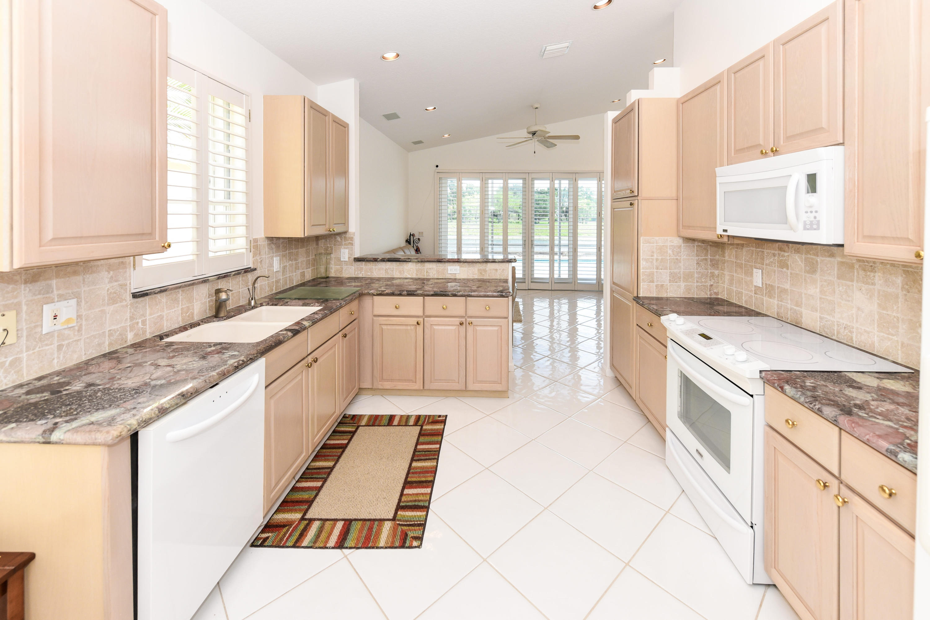23358 Torre Circle Boca Raton, FL 33433 - Photo 13 of 34 a large kitchen with stainless steel appliances granite countertop a sink and cabinets