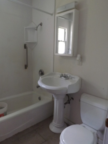 2411 West Cheyenne Road Waukegan, IL 60087 - Photo 9 of 18 a white toilet sitting next to a bath tub