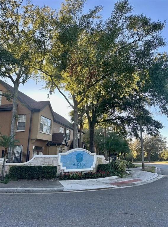 a front view of a house with a garden and tree