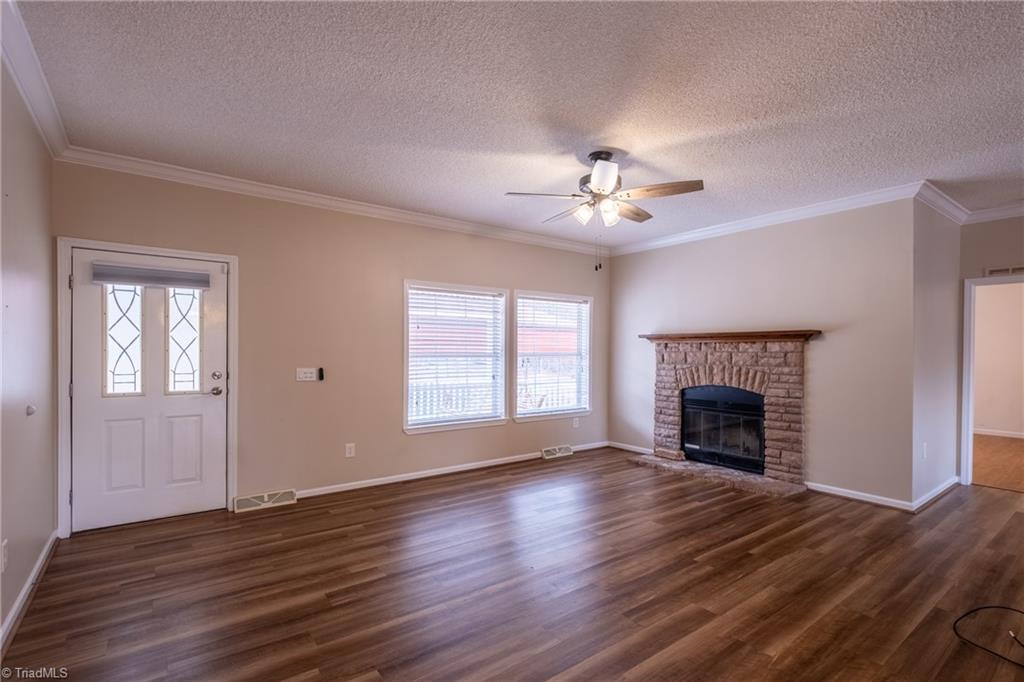 485 Amos Road Madison, NC 27025 - Photo 7 of 37 Front entry door and living room with fireplace