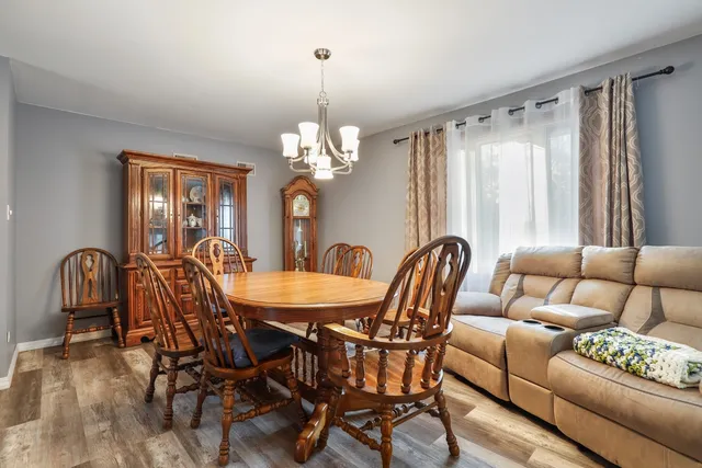 a dining room with furniture a chandelier and wooden floor