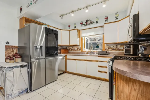 a kitchen with stainless steel appliances granite countertop a refrigerator sink and stove