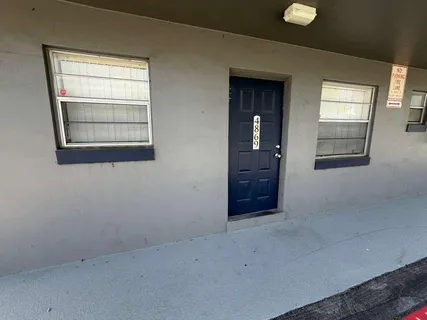 an empty room with windows and cabinet
