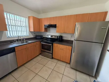 a kitchen with stainless steel appliances granite countertop a refrigerator sink and stove