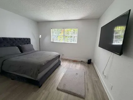 a bedroom with a bed and a flat screen tv