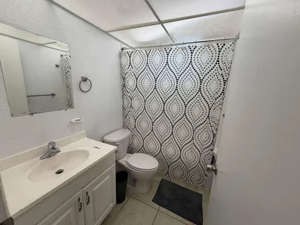 a bathroom with a sink toilet and shower