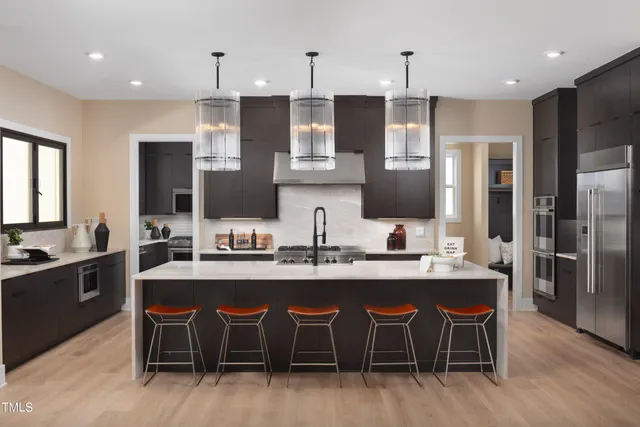 a kitchen with stainless steel appliances granite countertop a table chairs sink refrigerator and microwave