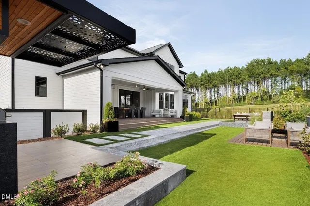 a view of a patio with table and chairs potted plants and large tree