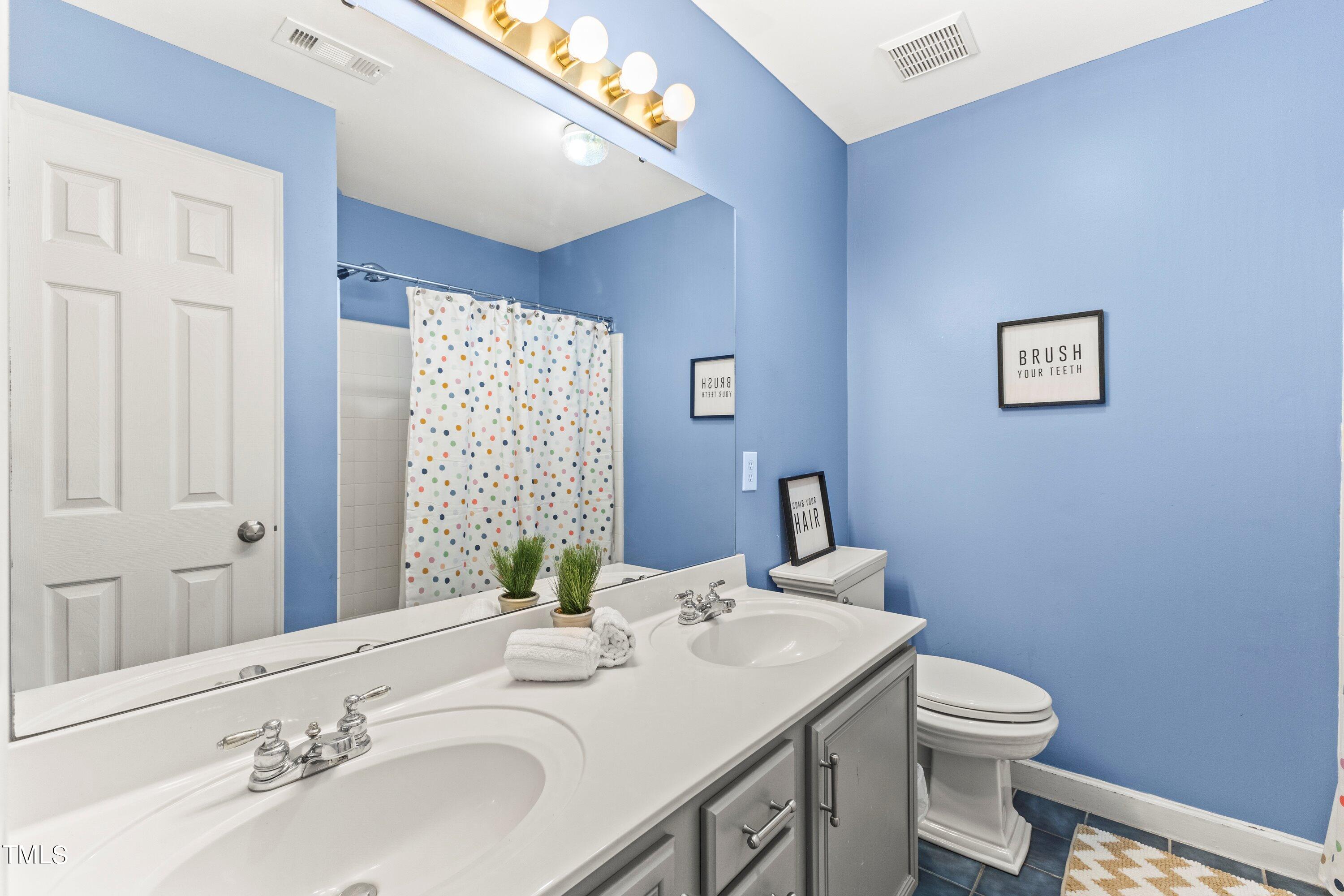12212 Penrose Trail Raleigh, NC 27614 - Photo 27 of 41 a bathroom with a sink a toilet and shower curtain