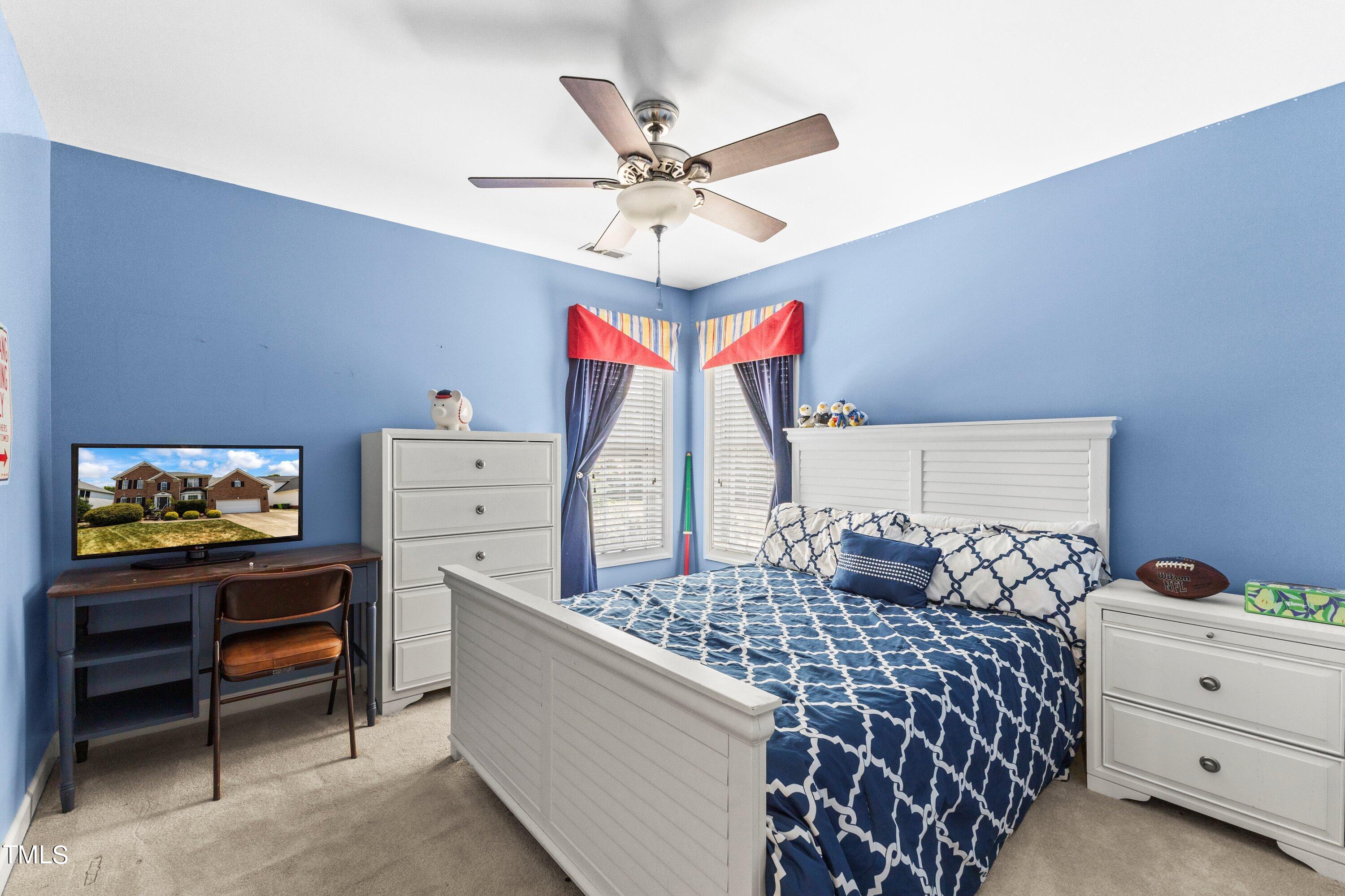 12212 Penrose Trail Raleigh, NC 27614 - Photo 29 of 41 a bedroom with a bed and a chandelier