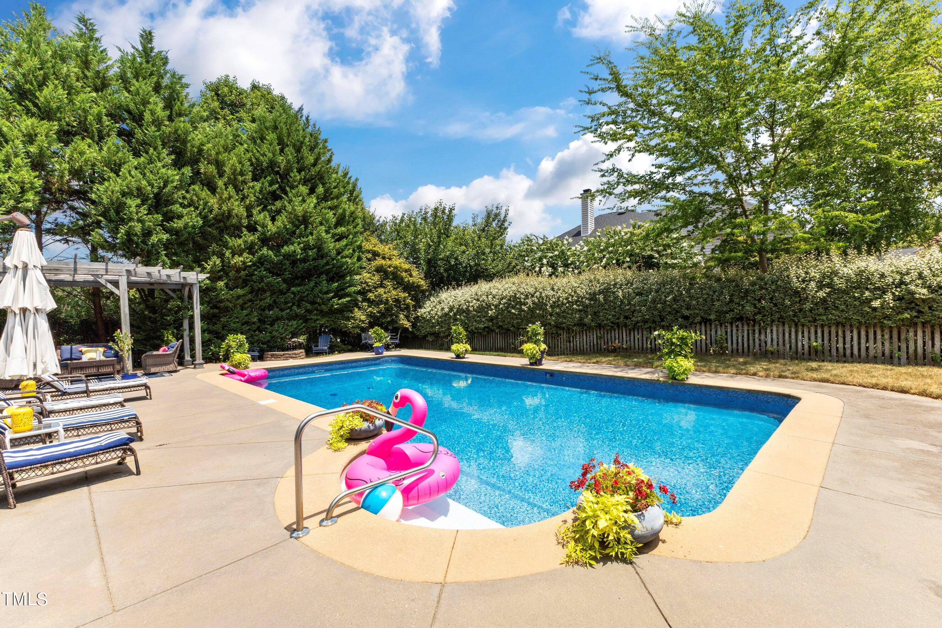 12212 Penrose Trail Raleigh, NC 27614 - Photo 37 of 41 a view of swimming pool with lounge chair and dinning table under an umbrella
