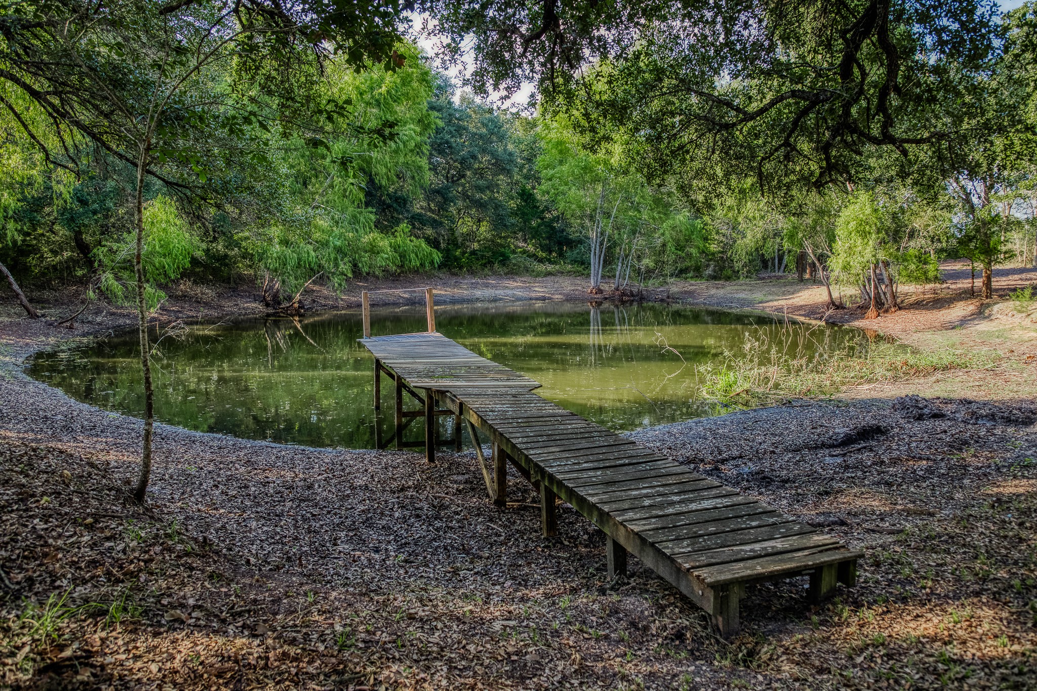 6 Sun Oil Road Brenham, TX 77833 - Photo 8 of 34 a view of a wooden deck with chairs and a lake view