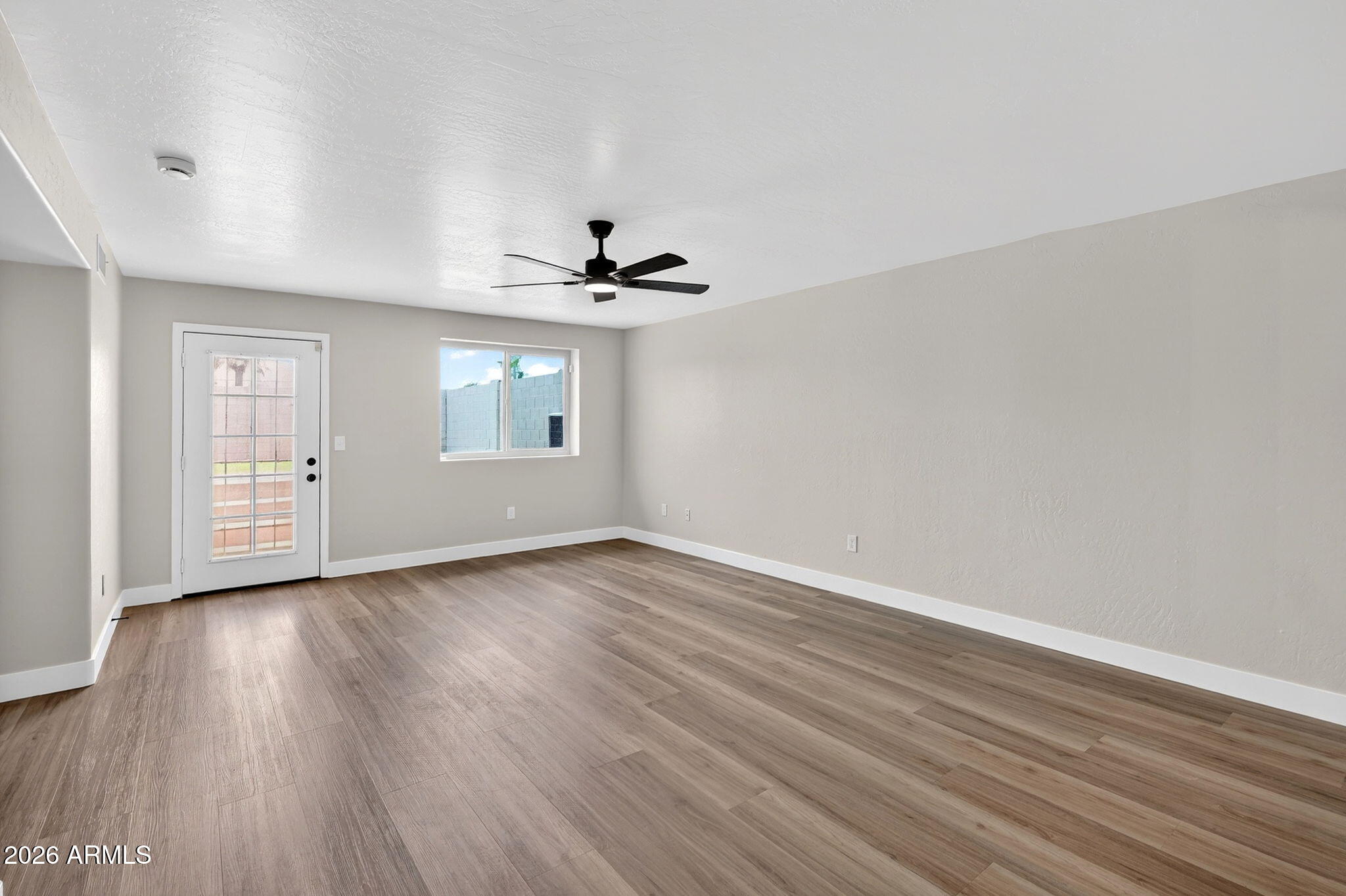 1417 East Mineral Road Gilbert, AZ 85234 - Photo 4 of 59 a view of an empty room with wooden floor and a window