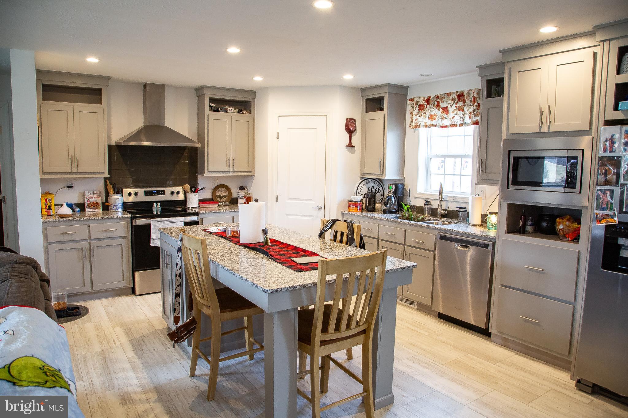 1101 Beaver Run Road Burlington, WV 26710 - Photo 3 of 40 a kitchen with a stove a sink a dining table and chairs