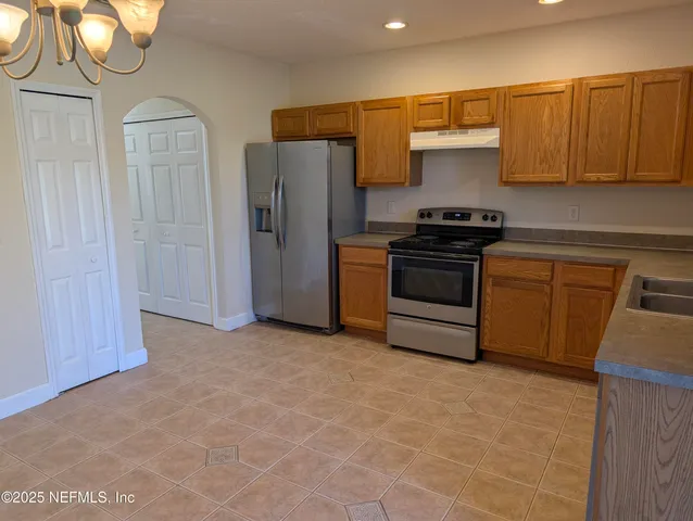 a kitchen with stainless steel appliances granite countertop a stove a refrigerator and a sink