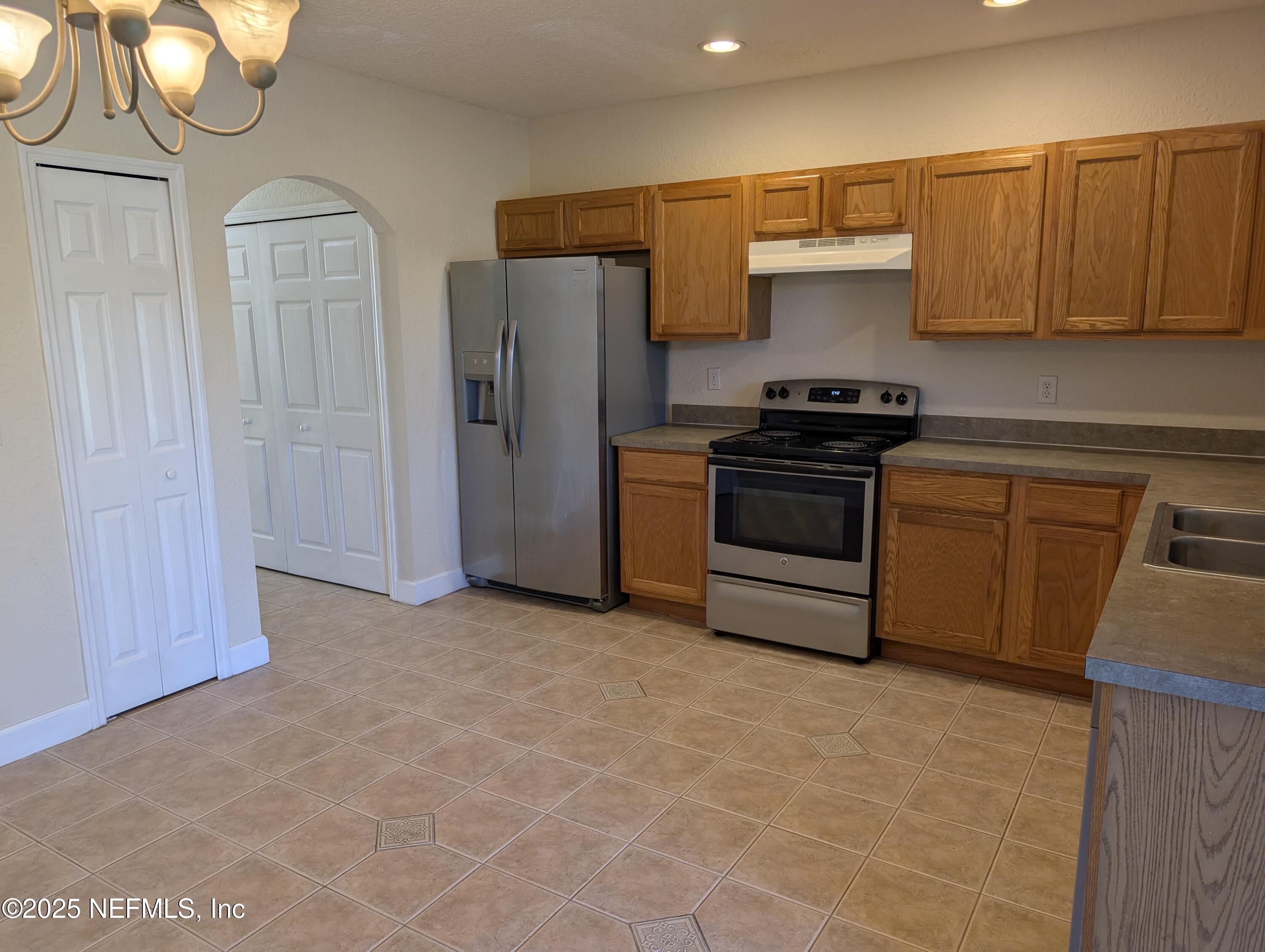1811 Lago Del Sur Drive Middleburg, FL 32068 - Photo 4 of 10 a kitchen with stainless steel appliances granite countertop a stove a refrigerator and a sink
