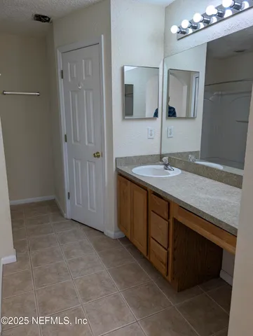 a bathroom with a granite countertop sink a mirror and a vanity