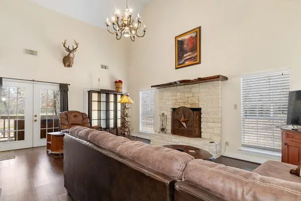 a living room with furniture chandelier and a fireplace