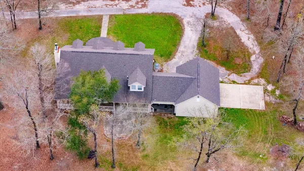 an aerial view of a house with a yard and a large tree