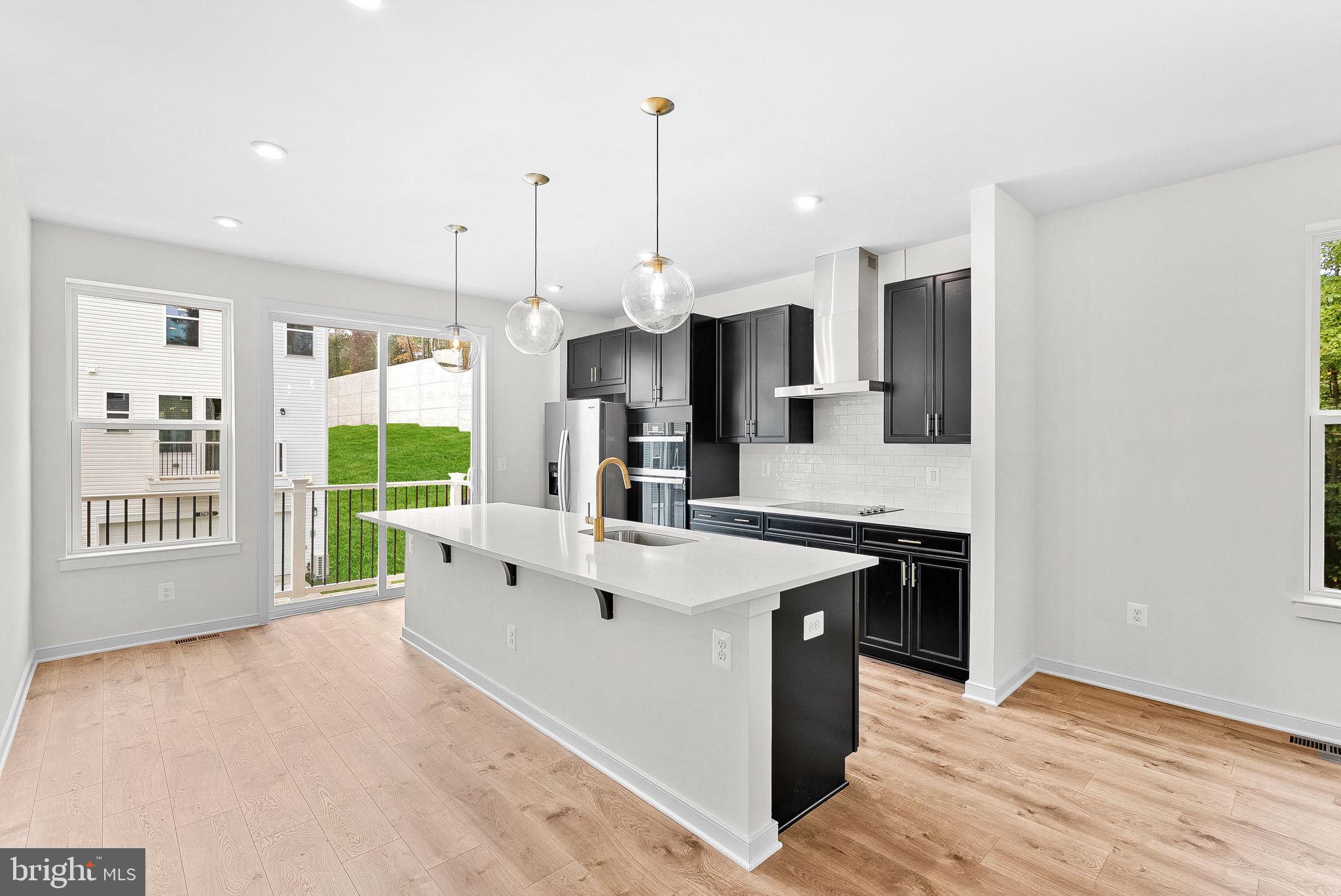 a large white kitchen with stainless steel appliances granite countertop a stove and a sink
