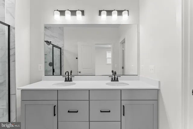 a bathroom with a shower sink and mirror