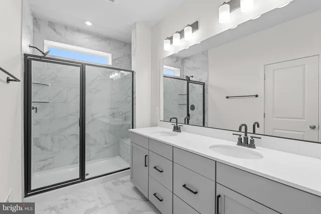 a bathroom with double vanity sink and shower