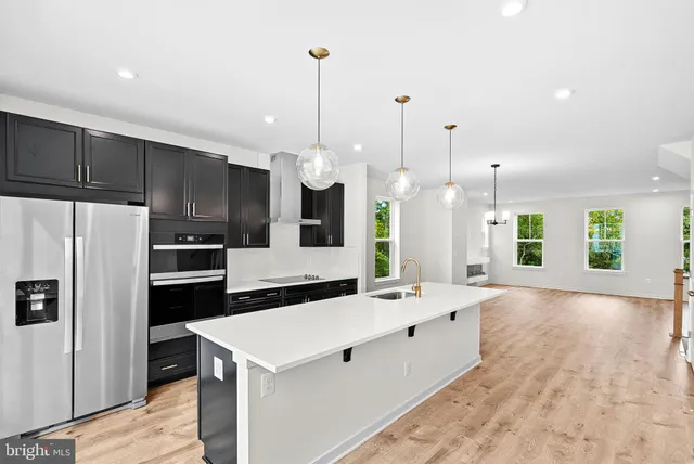 a large kitchen with kitchen island a sink stainless steel appliances and cabinets