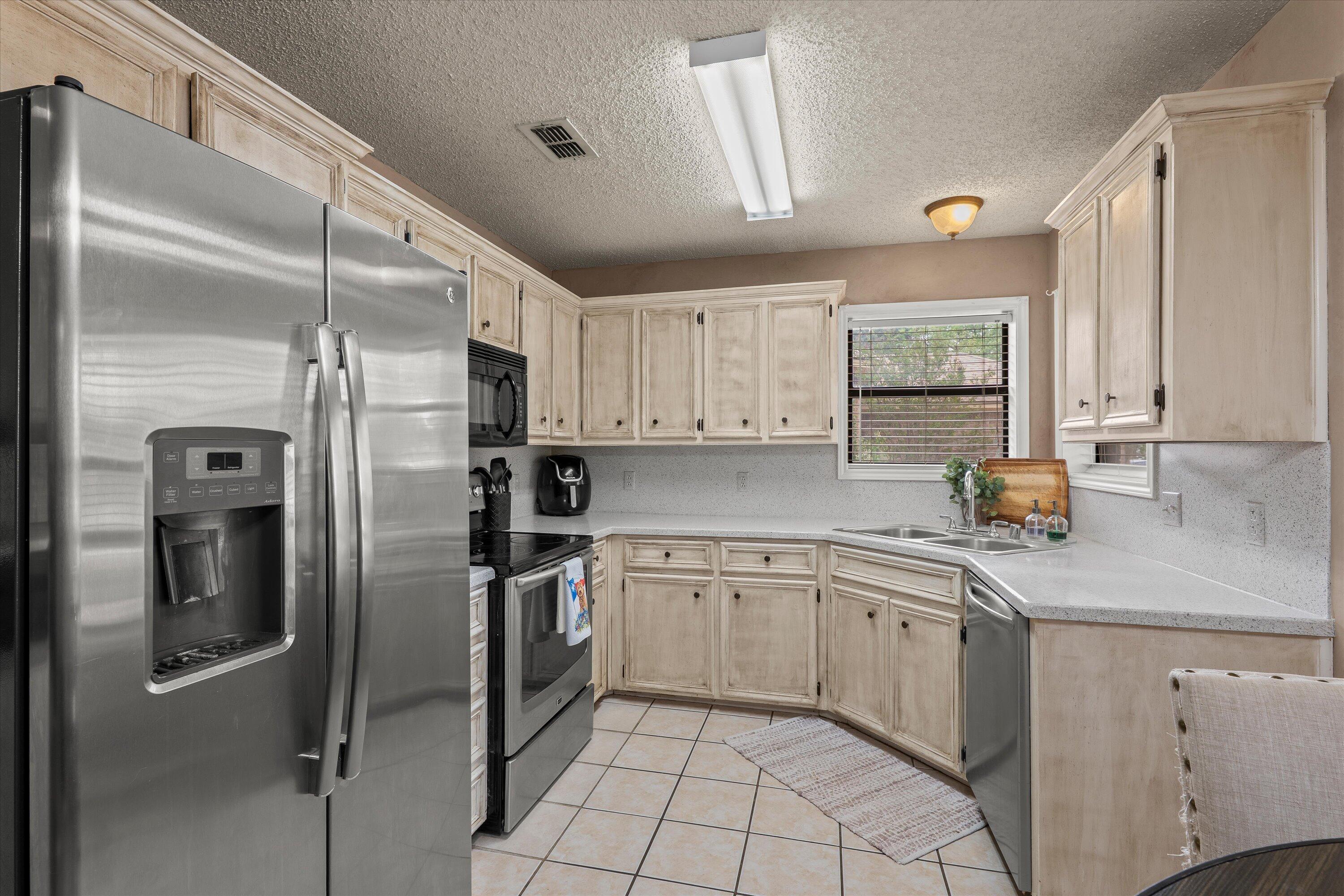 2308 93rd Street Lubbock, TX 79423 - Photo 11 of 28 a kitchen with a sink stainless steel appliances and cabinets