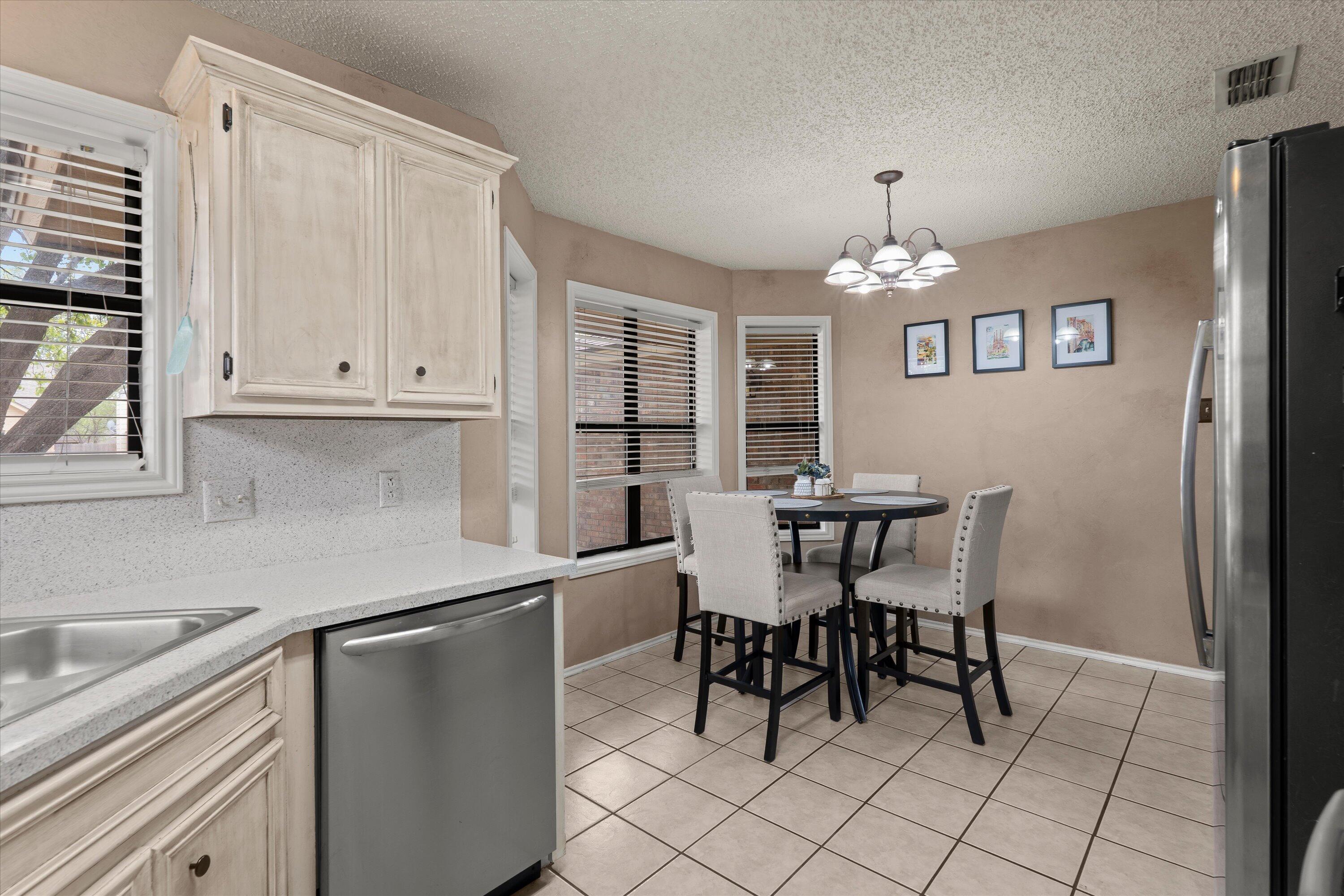 2308 93rd Street Lubbock, TX 79423 - Photo 12 of 28 a kitchen with stainless steel appliances a table and chairs in it