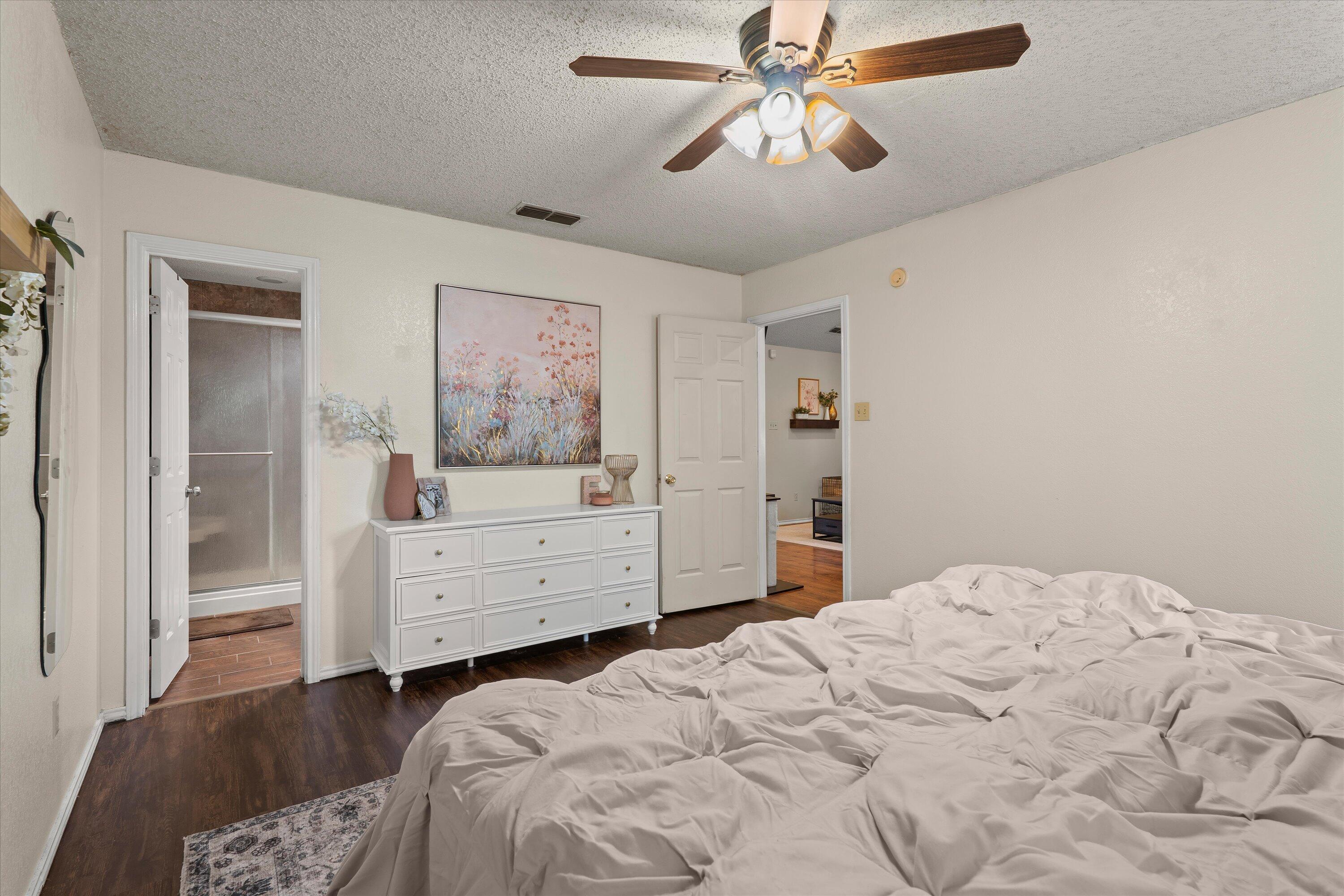 2308 93rd Street Lubbock, TX 79423 - Photo 15 of 28 a bedroom with a bed dresser and wooden floor